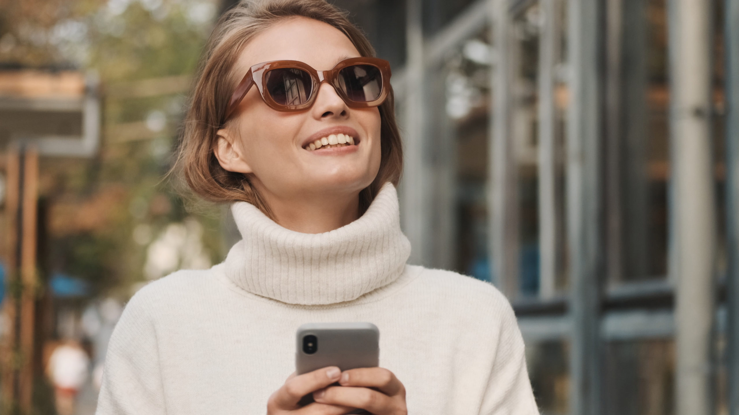 Attractive stylish girl in sunglasses dressed in white sweater l